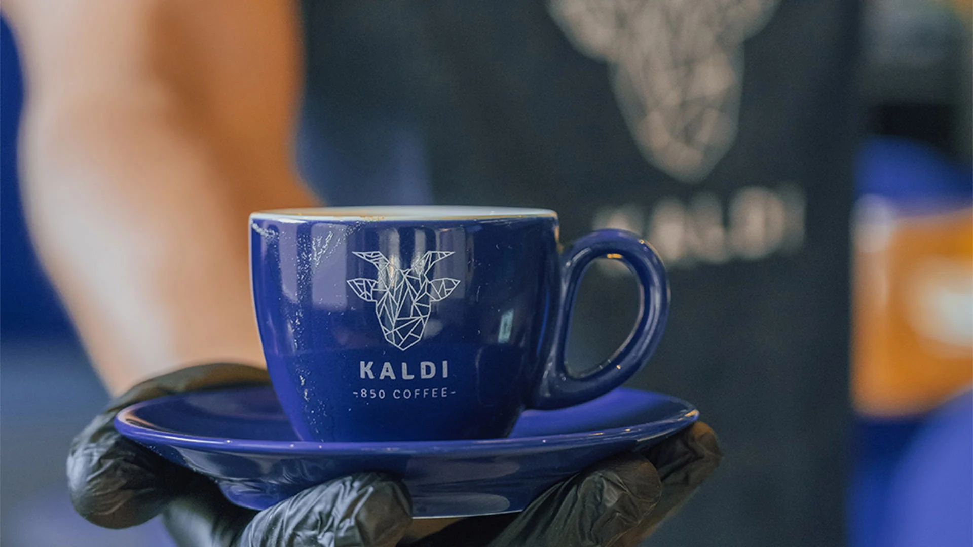 A Kaldi 850 barista holding a cup of tea